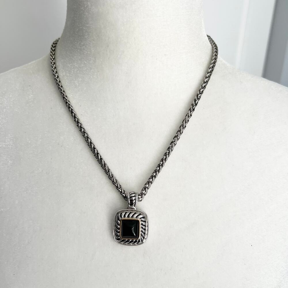 Silver tone braided link necklace with a black gold and silver tone pendant